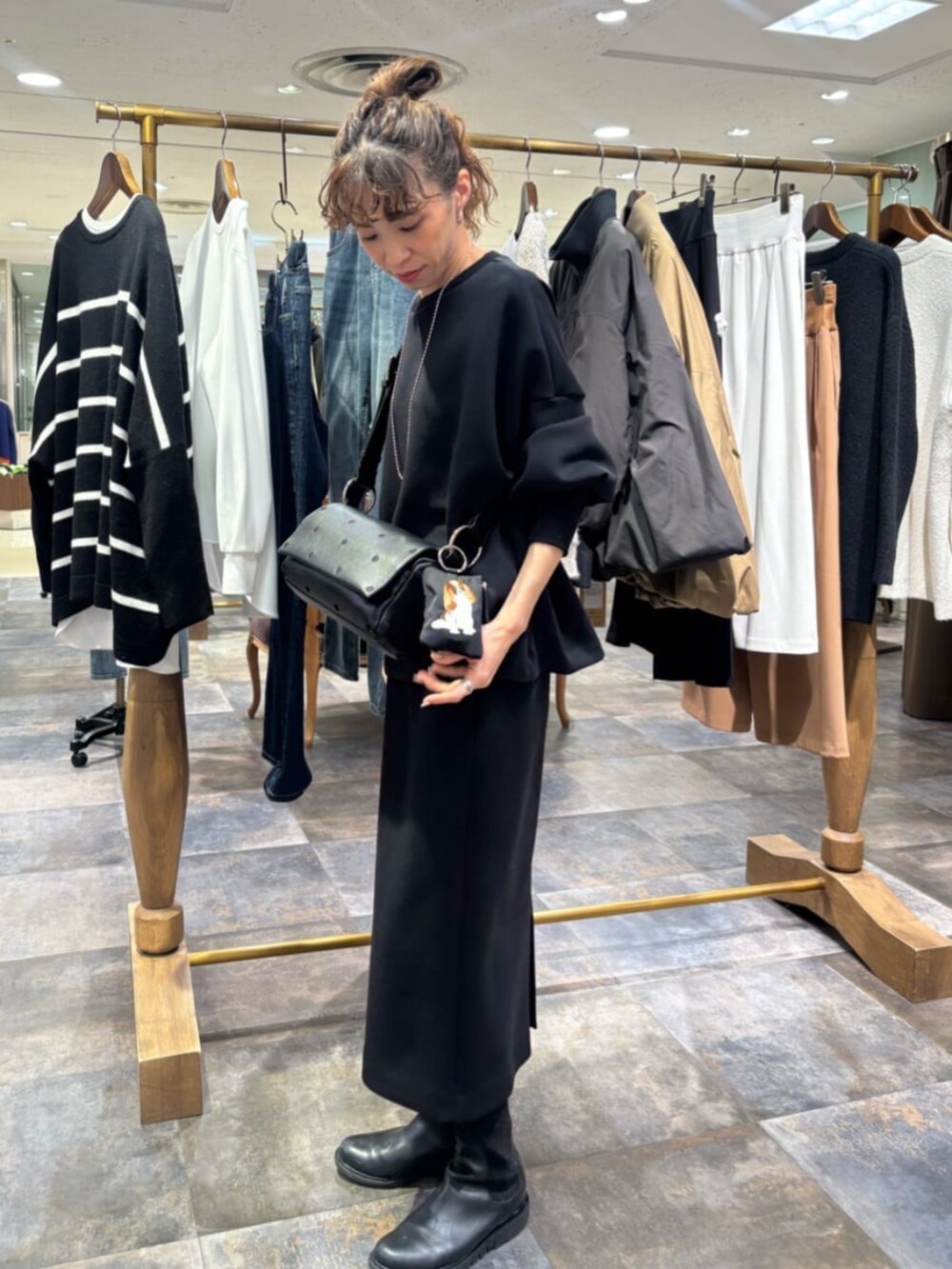 ブラック系のポーチを着用したレディースの冬コーディネートの2枚目の写真