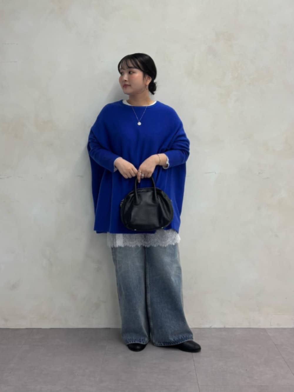 ブルー系のデニムパンツ、ブルー系のニット/セーター、ホワイト系のTシャツ/カットソーを着用したレディースの秋コーディネートの5枚目の写真