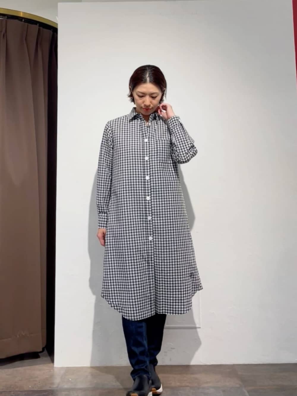 ブルー系のデニムパンツ、ブラック系のワンピース、ホワイト系のトートバッグを着用したレディースの春コーディネートの5枚目の写真