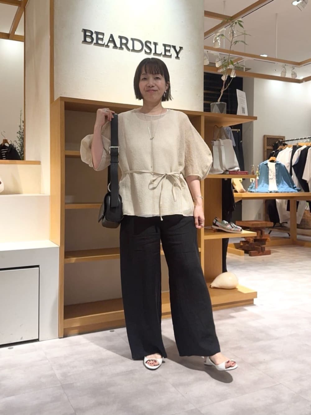 ベージュ系のシャツ/ブラウス、ブラック系のその他パンツを着用したレディースの春コーディネートの5枚目の写真