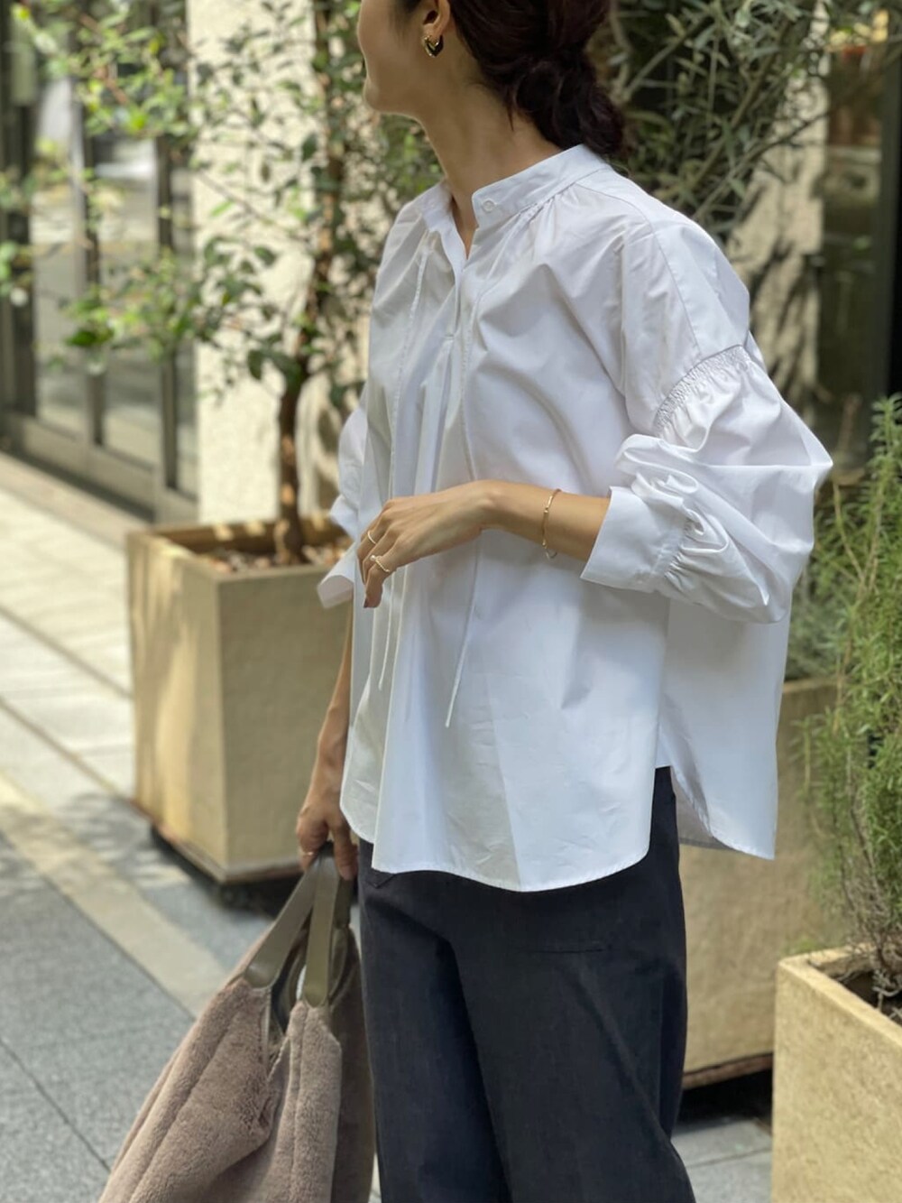 ホワイト系のシャツ/ブラウス、ブルー系のデニムパンツ、ブラウン系のトートバッグを着用したレディースの夏コーディネートの3枚目の写真