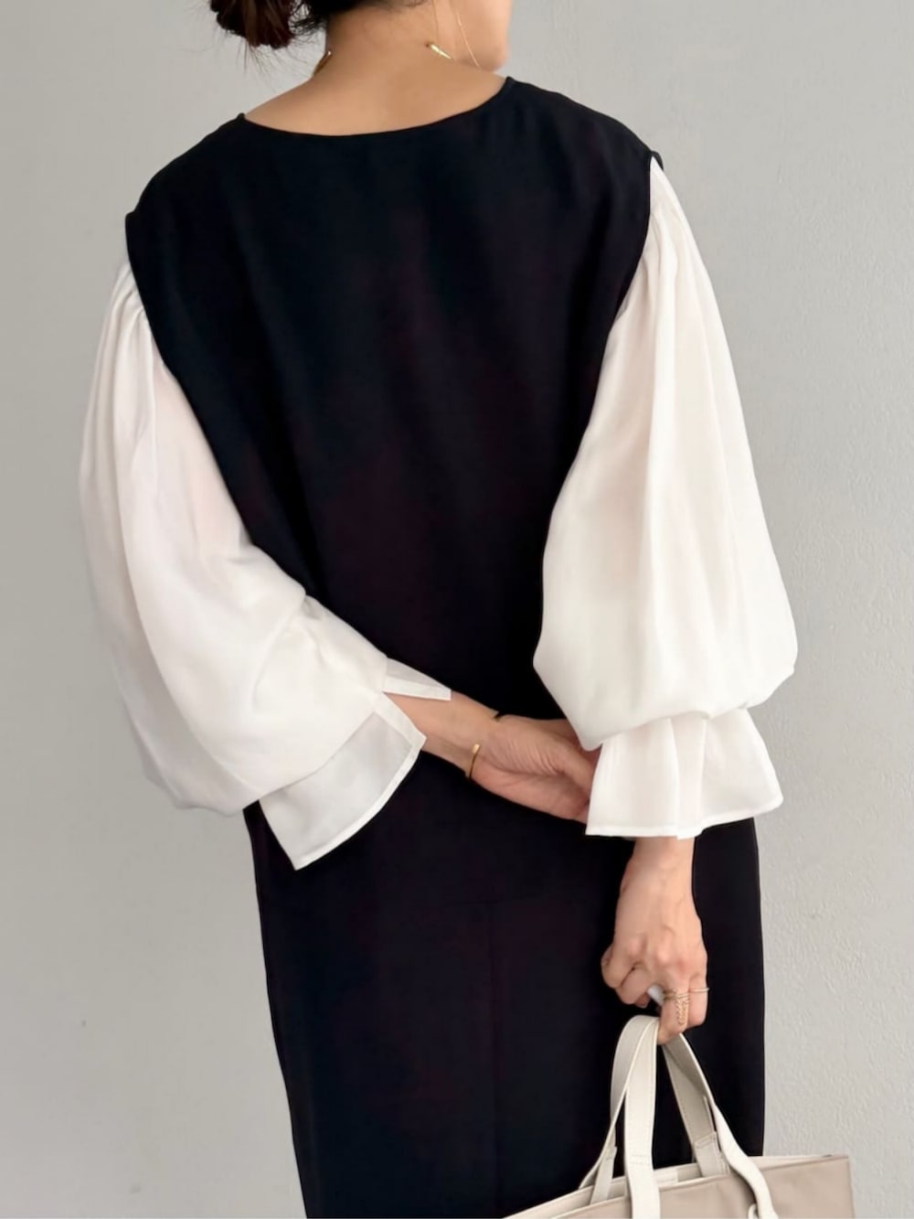 ホワイト系のシャツ/ブラウス、ブラック系のジャンパースカート、グレー系のパンプスを着用したレディースの秋コーディネートの8枚目の写真