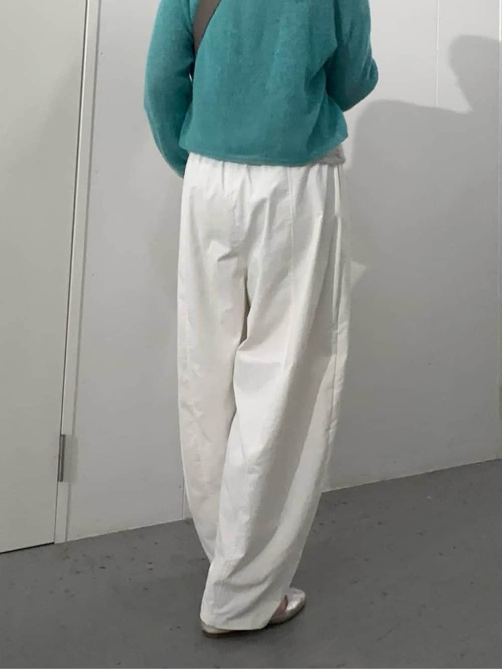 グレー系のショルダーバッグ、ブルー系のニット/セーター、ホワイト系のその他パンツを着用したレディースの夏コーディネートの2枚目の写真