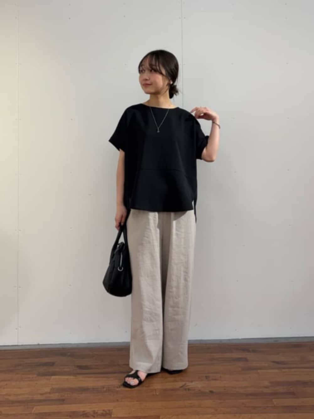 ブラック系のボストンバッグ、ブラック系のシャツ/ブラウス、グレー系のその他パンツを着用したレディースの春コーディネートの2枚目の写真