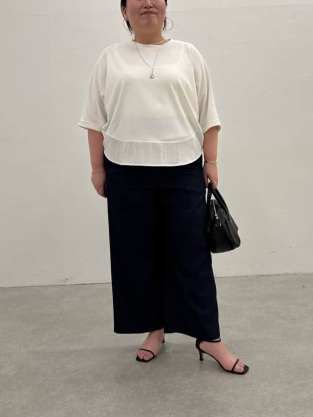 ブラック系のボストンバッグ、ブルー系のその他パンツ、ホワイト系のTシャツ/カットソーを着用したレディースの春コーディネートの4枚目の写真