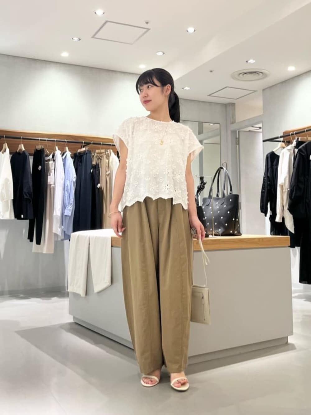ホワイト系のショルダーバッグ、イエロー系のその他パンツ、ホワイト系のシャツ/ブラウスを着用したレディースの夏コーディネートの6枚目の写真