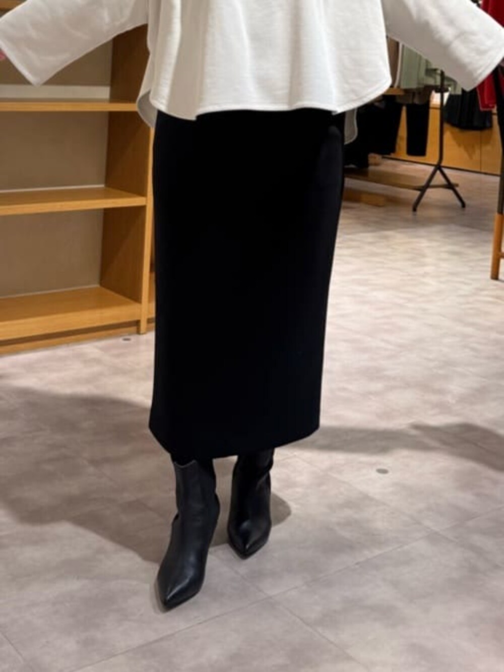 ブラック系のブーツ、ブラック系のスカート、ホワイト系のTシャツ/カットソーを着用したレディースの冬コーディネートの9枚目の写真