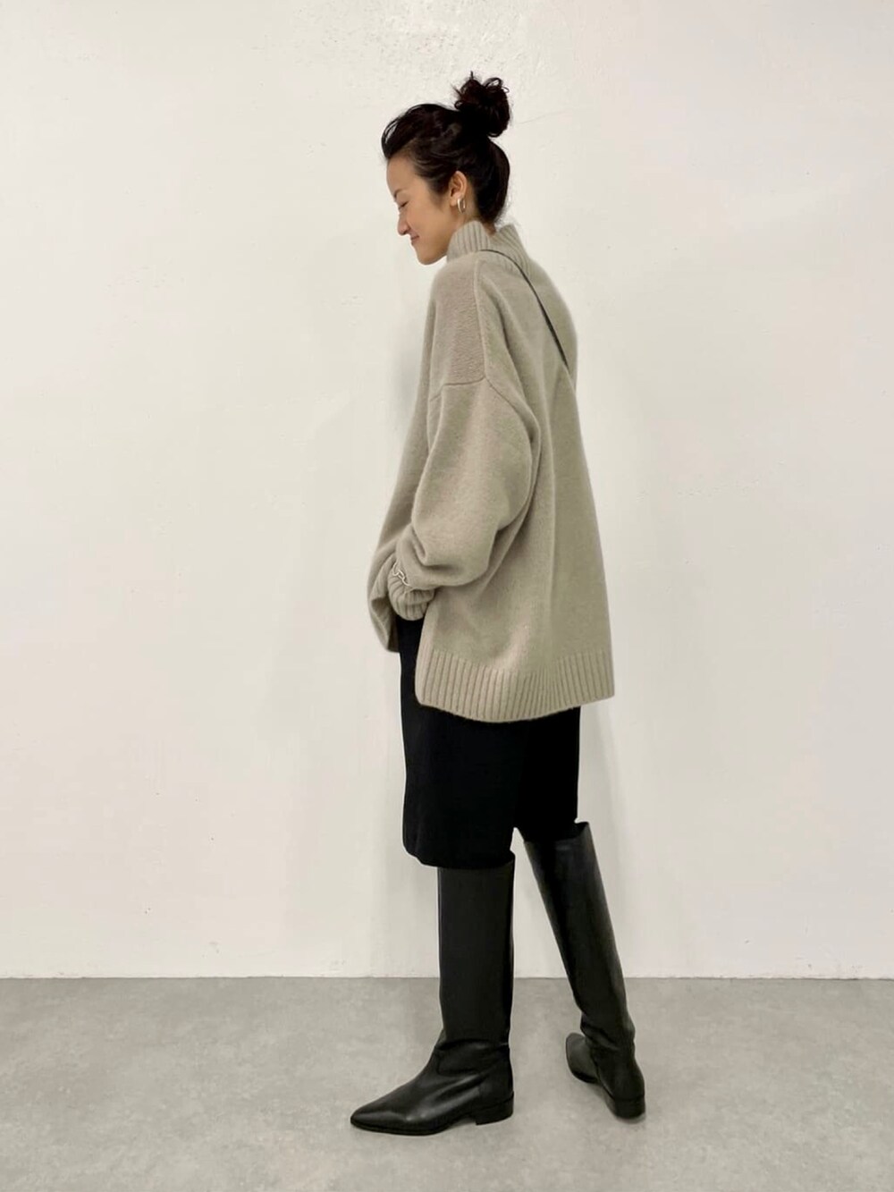 ブラック系のその他パンツ、ブラック系のノーカラーコート、グリーン系のニット/セーターを着用したレディースの秋コーディネートの3枚目の写真