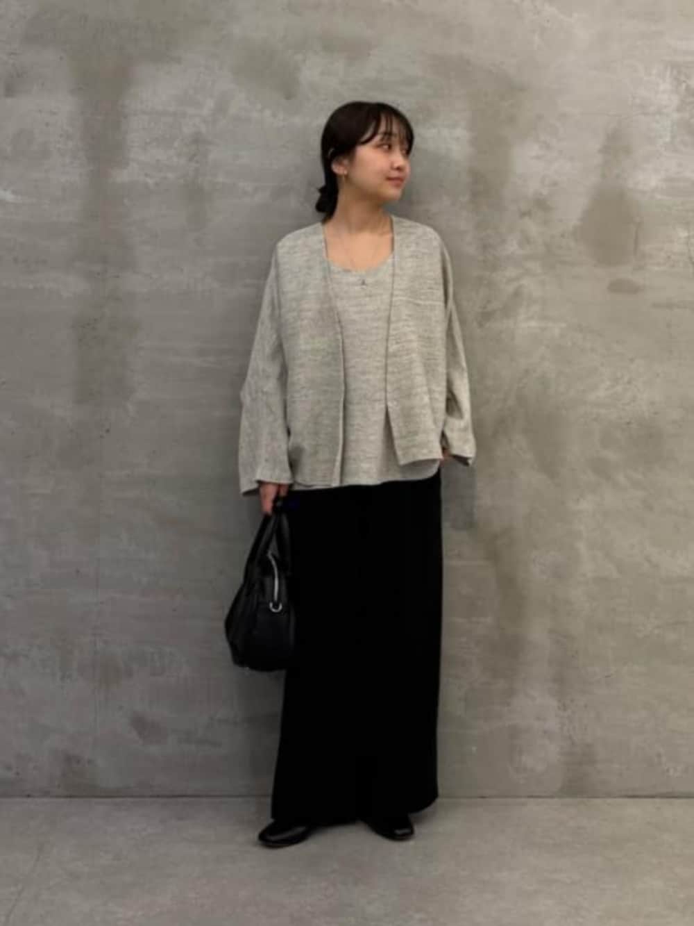 ブラック系のボストンバッグ、グレー系のニット/セーター、グレー系のカーディガン/ボレロを着用したレディースの春コーディネートの5枚目の写真