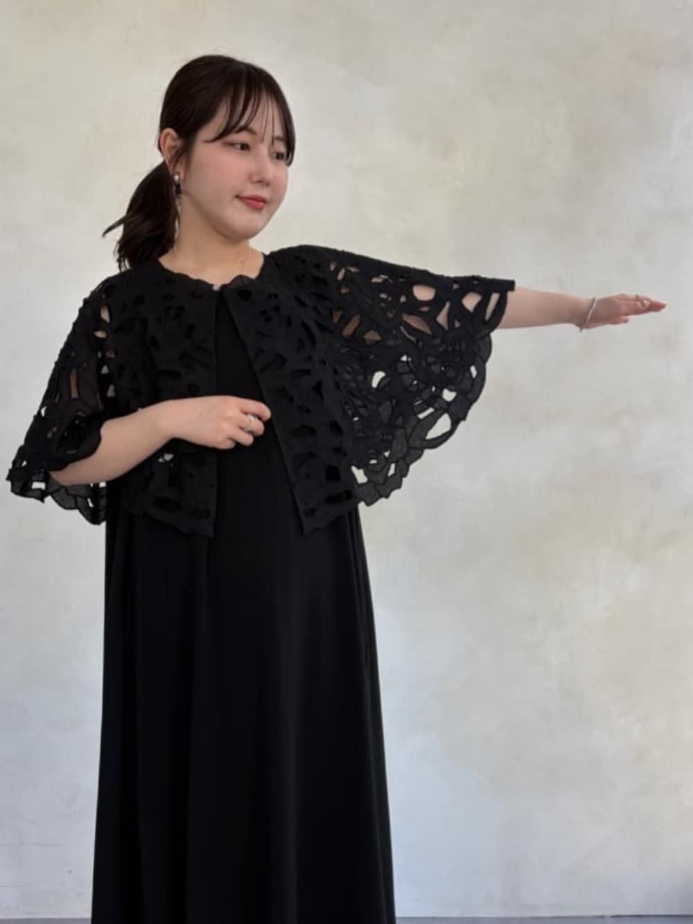 グレー系のハンドバッグ、ブラック系のワンピース、ブラック系のシャツ/ブラウスを着用したレディースの春コーディネートの5枚目の写真