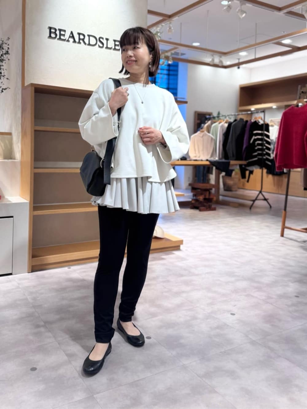 ブラック系のその他パンツ、ブラック系のショルダーバッグ、ホワイト系のTシャツ/カットソーを着用したレディースの冬コーディネートの3枚目の写真