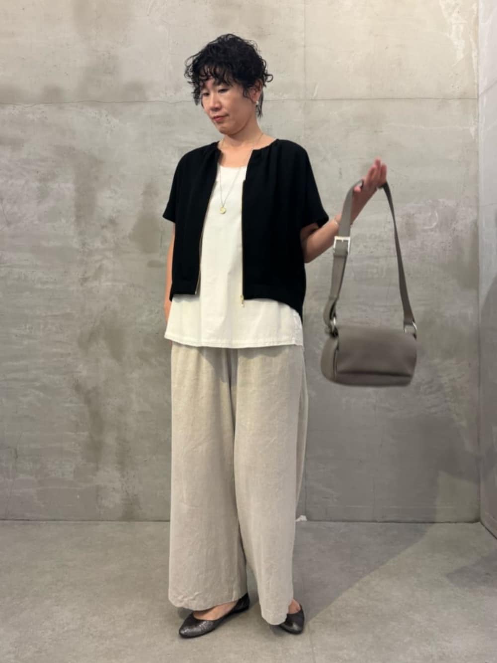 ベージュ系のその他パンツ、ホワイト系のシャツ/ブラウス、ブラック系のベストを着用したレディースの春コーディネートの4枚目の写真