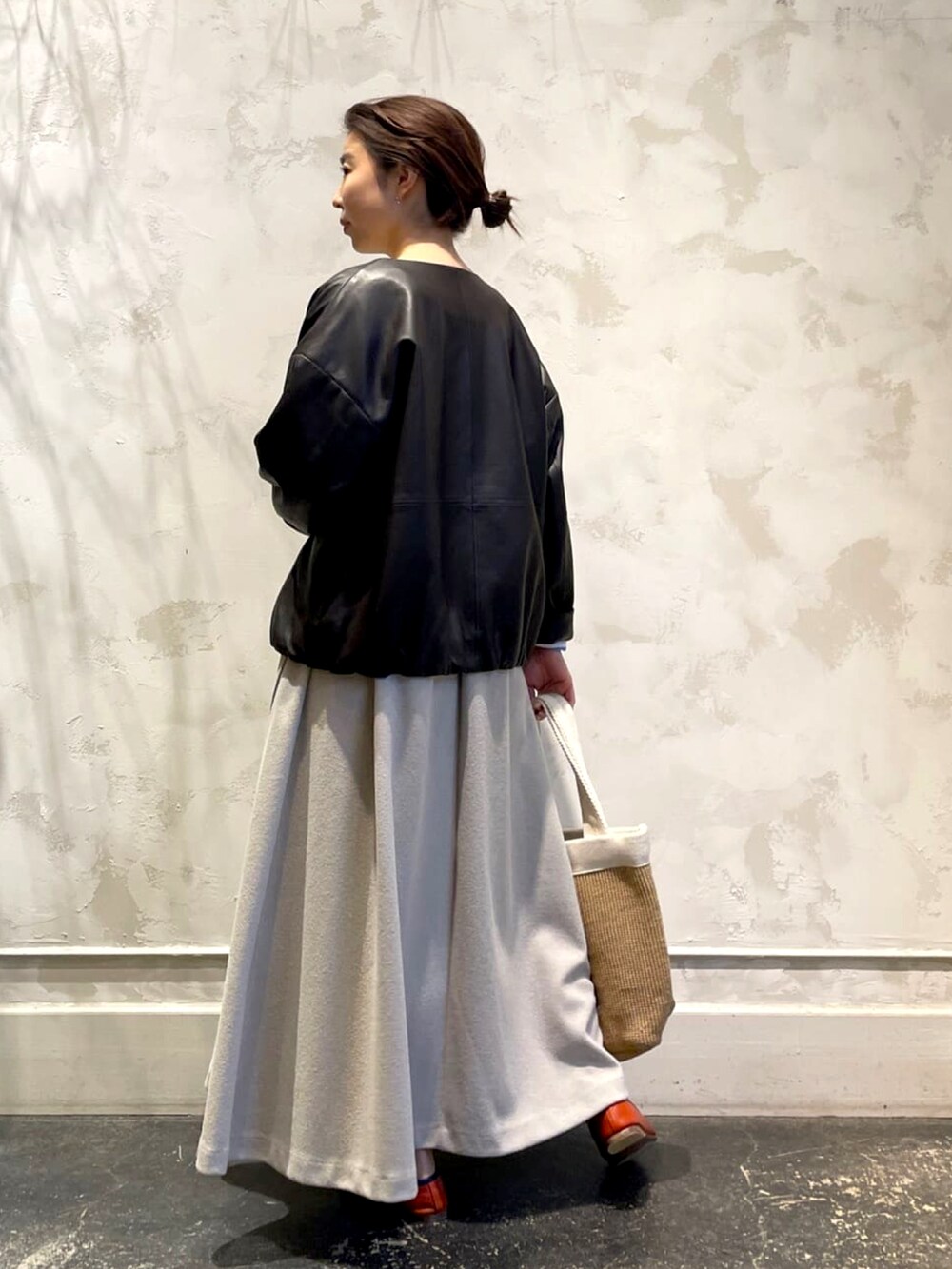 グレー系のワンピース、ブラウン系のブルゾン、ブルー系のニット/セーターを着用したレディースの春コーディネートの2枚目の写真