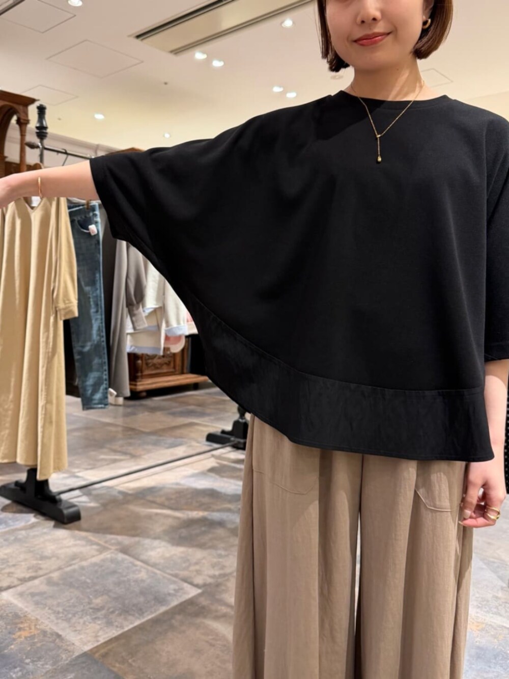 ベージュ系のその他パンツ、ブラック系のTシャツ/カットソーを着用したレディースの春コーディネートの7枚目の写真