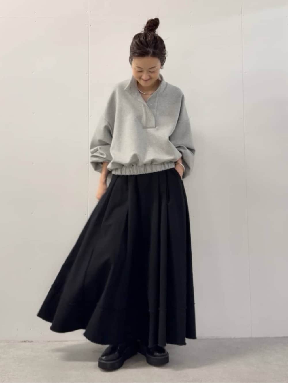 ブラック系のショルダーバッグ、ブラック系のスカート、グレー系のTシャツ/カットソーを着用したレディースの夏コーディネートの5枚目の写真