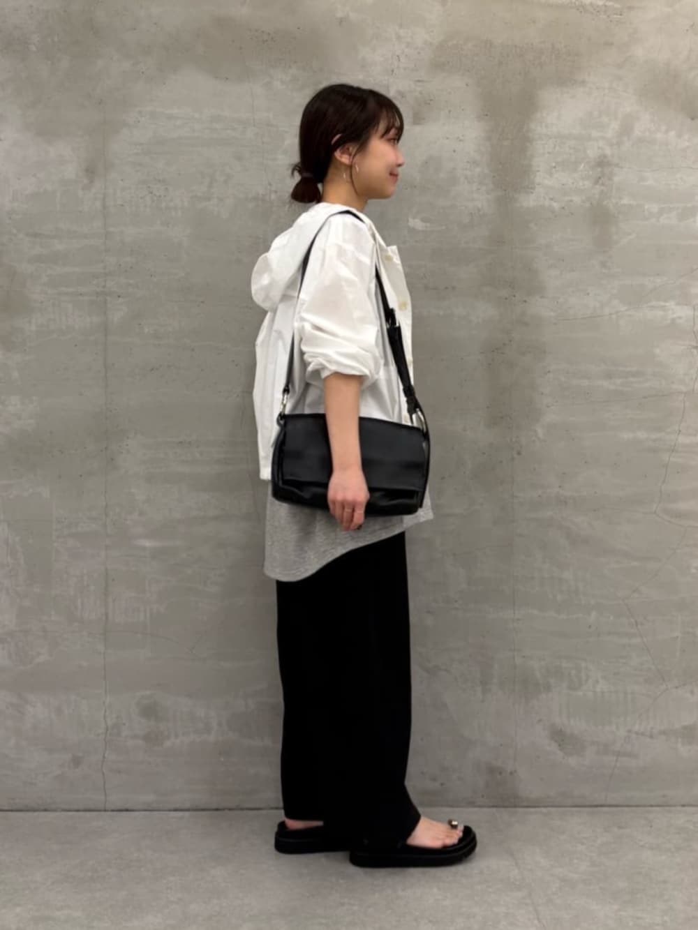 ブラック系のショルダーバッグ、ブラック系のサンダル、ホワイト系のシャツ/ブラウスを着用したレディースの冬コーディネートの5枚目の写真