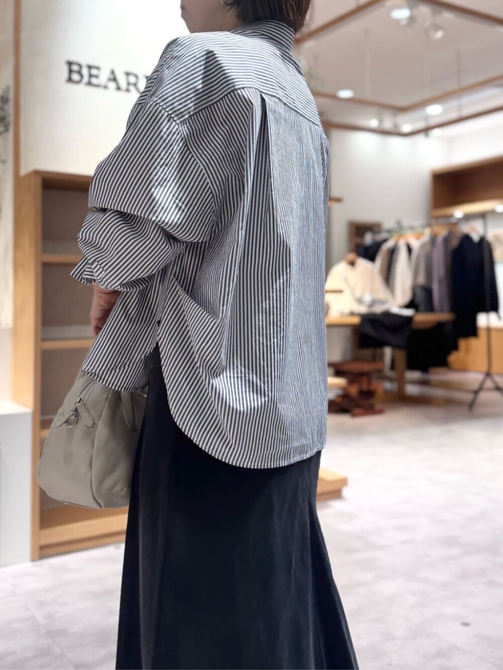 ブラック系のスカート、グレー系のボストンバッグ、ブルー系のシャツ/ブラウスを着用したレディースの冬コーディネートの3枚目の写真