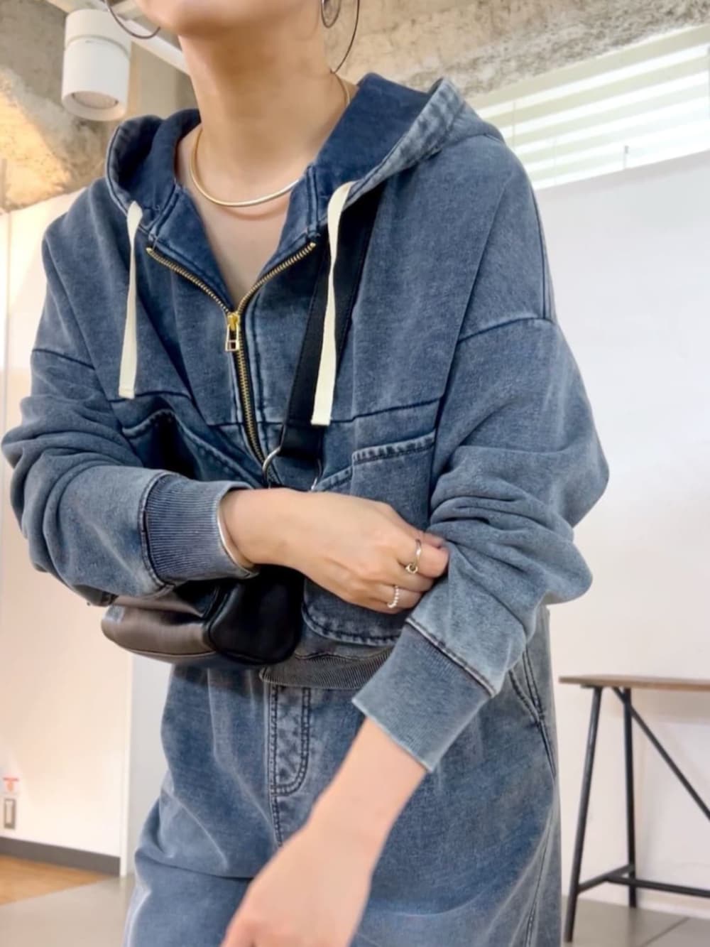 ブラック系のショルダーバッグ、ブルー系のその他パンツ、ブルー系のパーカーを着用したレディースの秋コーディネートの2枚目の写真
