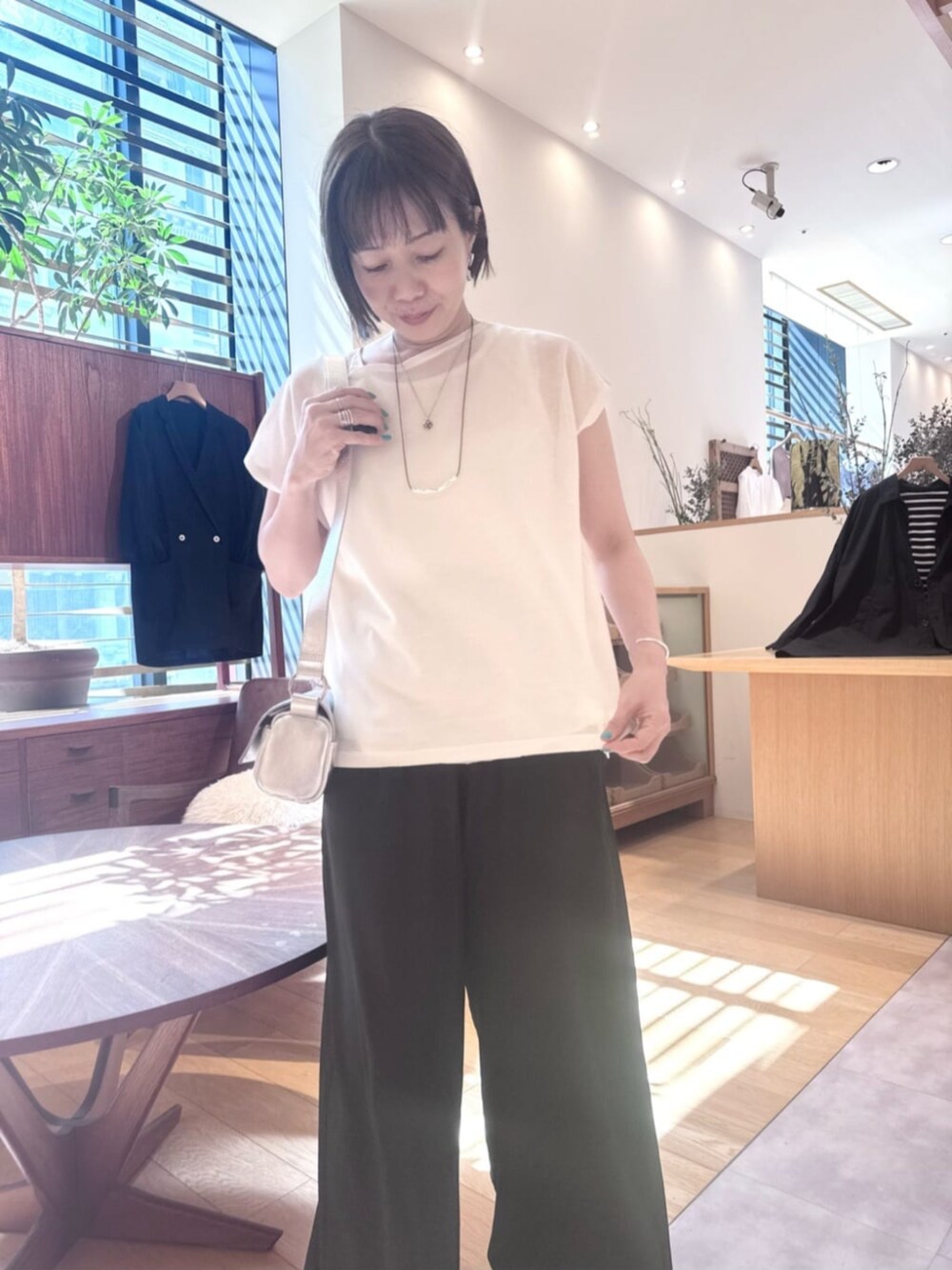 ホワイト系のニット/セーターを着用したレディースの夏コーディネートの5枚目の写真