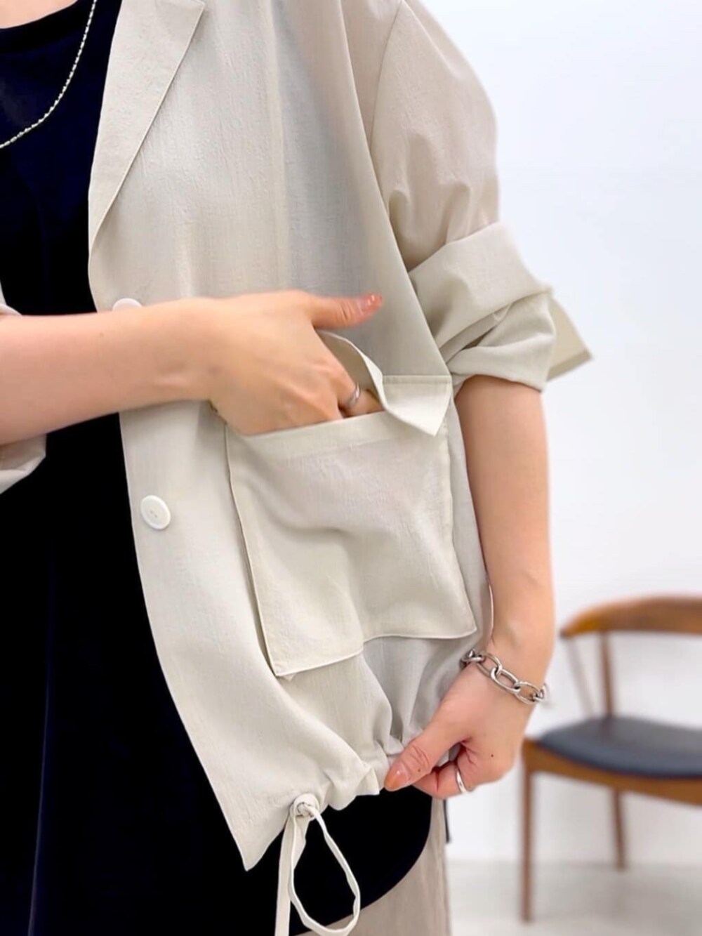 ブラック系のキャミソール、ホワイト系のブルゾン、グレー系のその他パンツを着用したレディースの夏コーディネートの10枚目の写真
