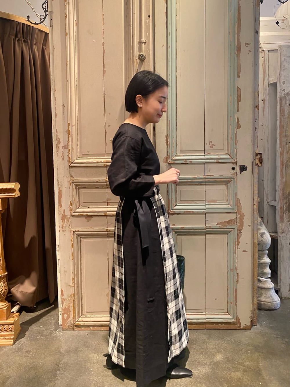 ブラック系のノーカラージャケット、ブラック系のワンピース、グリーン系のトートバッグを着用したレディースの春コーディネートの2枚目の写真