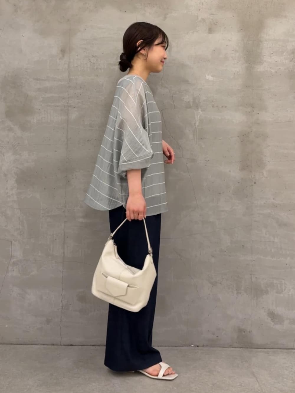 ブルー系のその他パンツ、ホワイト系のトートバッグ、グレー系のシャツ/ブラウスを着用したレディースの春コーディネートの5枚目の写真