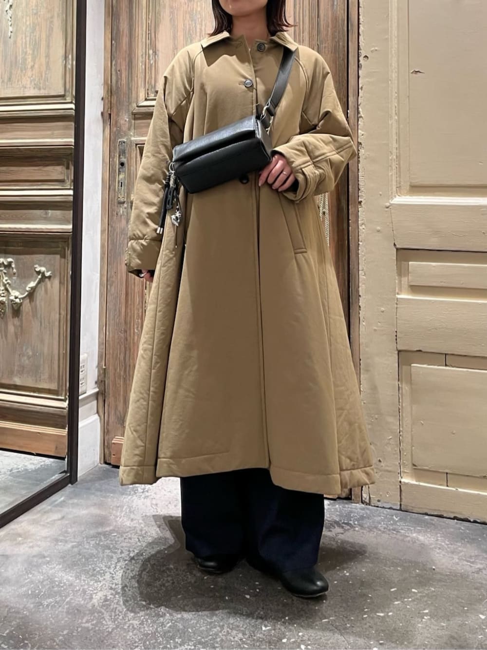 ブラック系のショルダーバッグ、イエロー系のその他アウター、ブラック系のチャームを着用したレディースの冬コーディネートの2枚目の写真