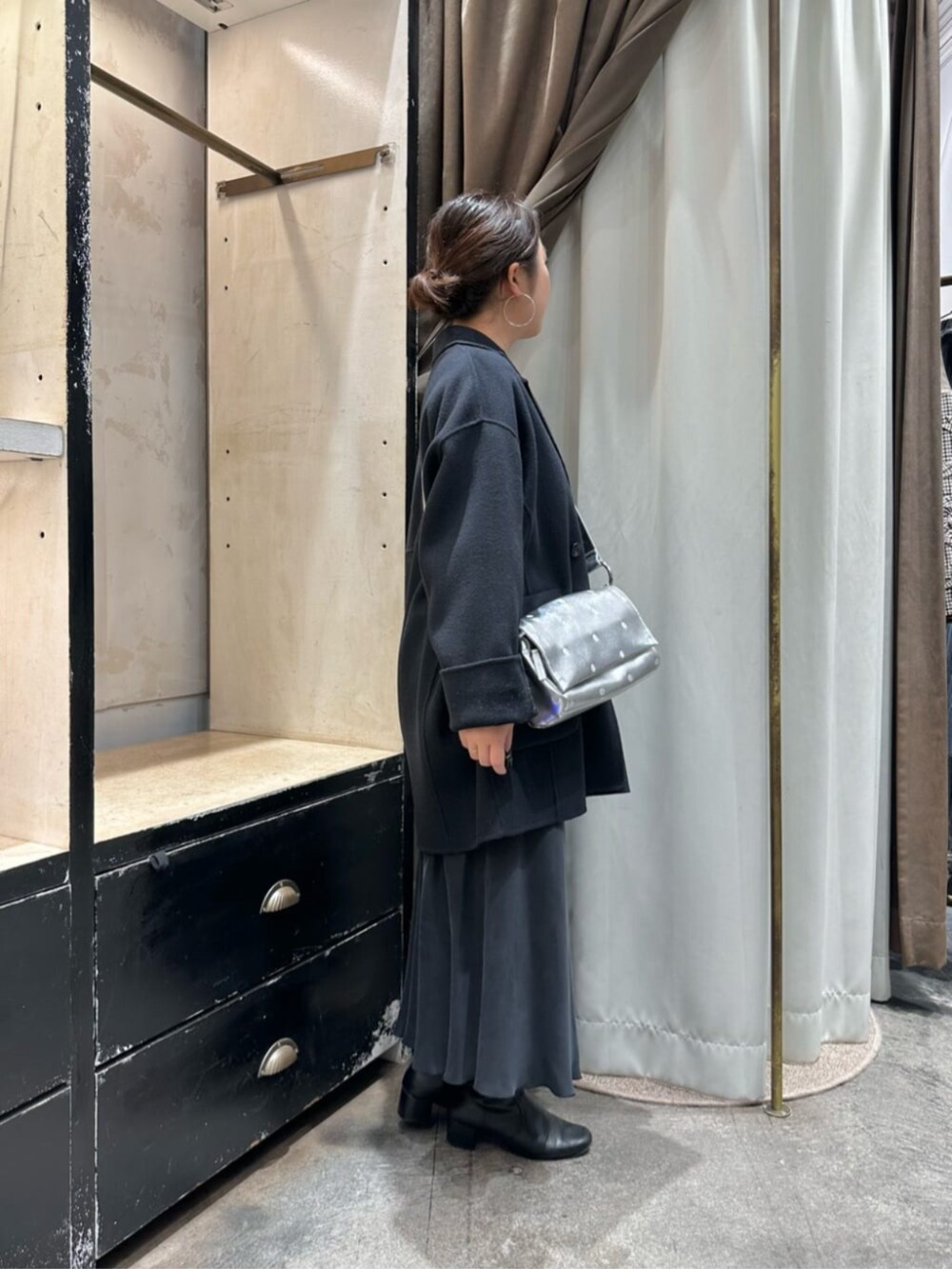 ブラック系のスカート、ブルー系のピーコート、シルバー系のショルダーバッグを着用したレディースの冬コーディネートの4枚目の写真