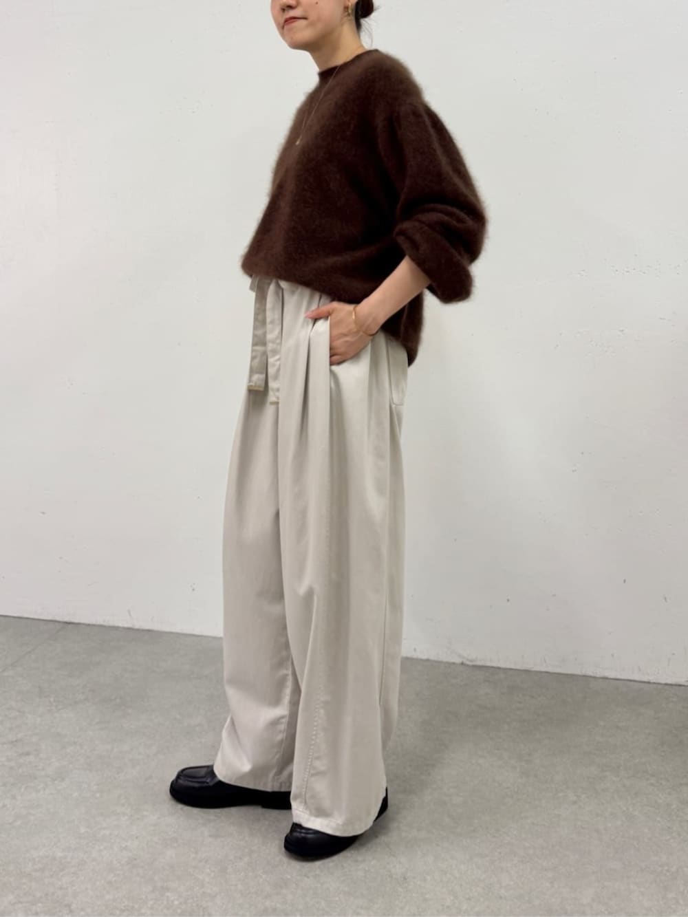 ブラック系のローファー、ホワイト系のその他パンツ、ブラウン系のニット/セーターを着用したレディースの秋コーディネートの2枚目の写真