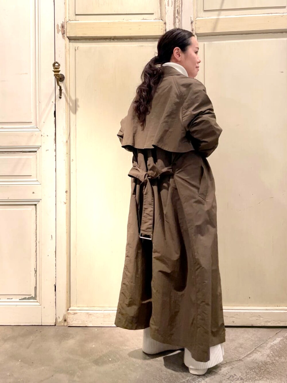 グリーン系のその他アウター、ホワイト系のニット/セーター、ホワイト系のその他パンツを着用したレディースの春コーディネートの2枚目の写真