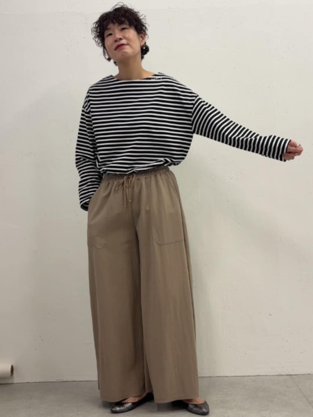 ブルー系のその他アウター、ベージュ系のその他パンツ、ブラック系のTシャツ/カットソーを着用したレディースの冬コーディネートの7枚目の写真