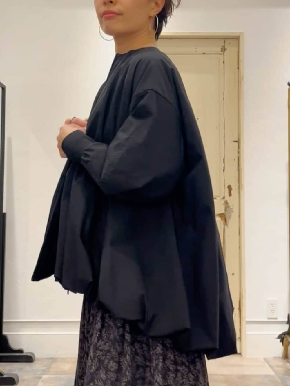 ブラック系のスカート、ベージュ系のショルダーバッグ、ブラック系のブルゾンを着用したレディースの冬コーディネートの7枚目の写真