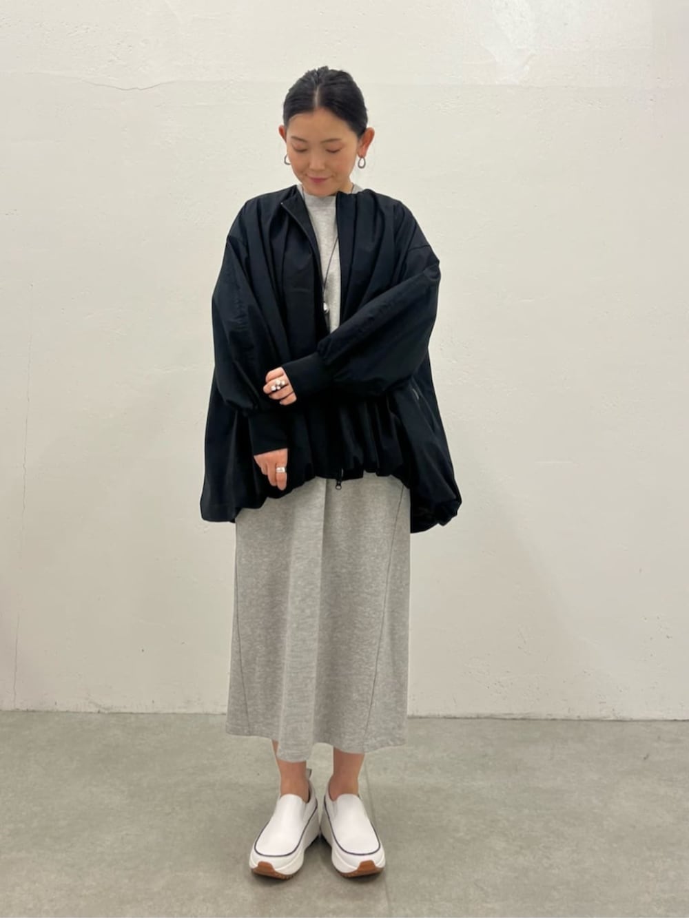 ブラック系のブルゾン、グレー系のワンピースを着用したレディースの冬コーディネートの4枚目の写真