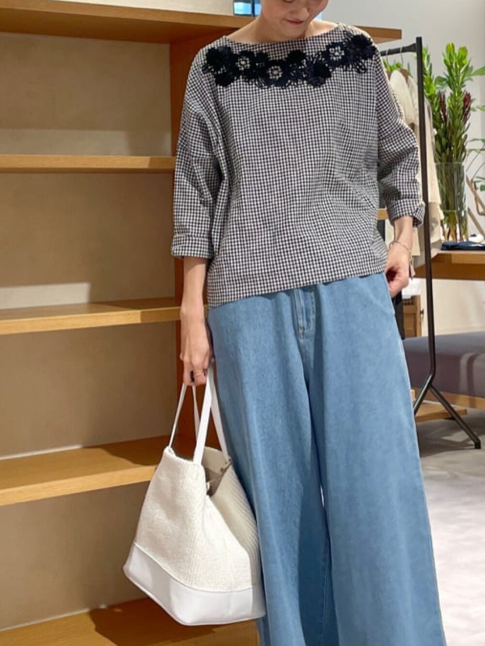 ブラック系のシャツ/ブラウス、ブルー系のデニムパンツ、ホワイト系のトートバッグを着用したレディースの春コーディネートの2枚目の写真