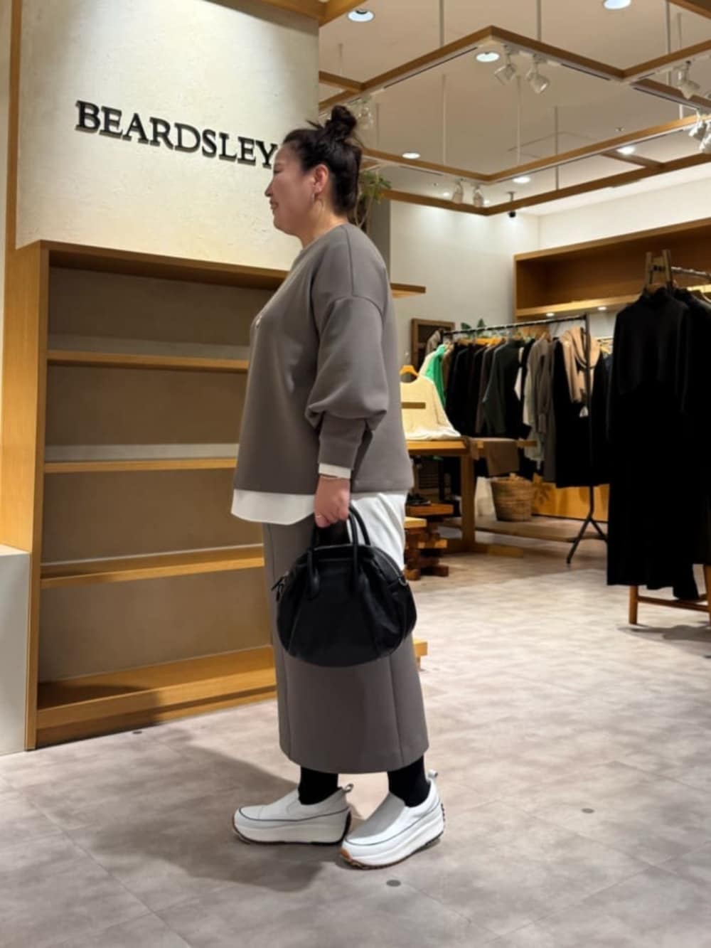 ホワイト系のスニーカー、ブラック系のボストンバッグ、ホワイト系のシャツ/ブラウスを着用したレディースの冬コーディネートの5枚目の写真