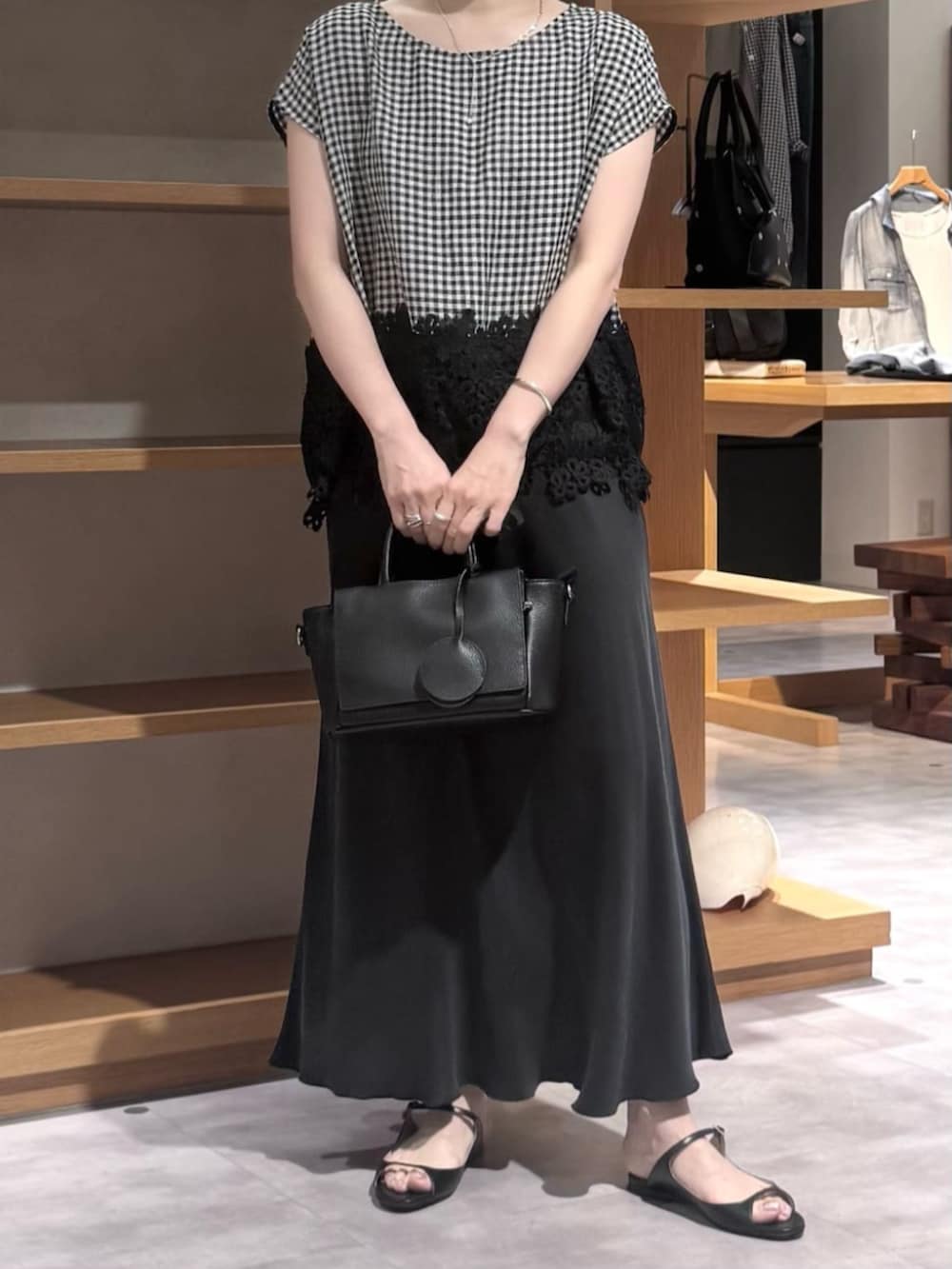 ブラック系のスカート、ブラック系のハンドバッグ、ブラック系のシャツ/ブラウスを着用したレディースの春コーディネートの6枚目の写真