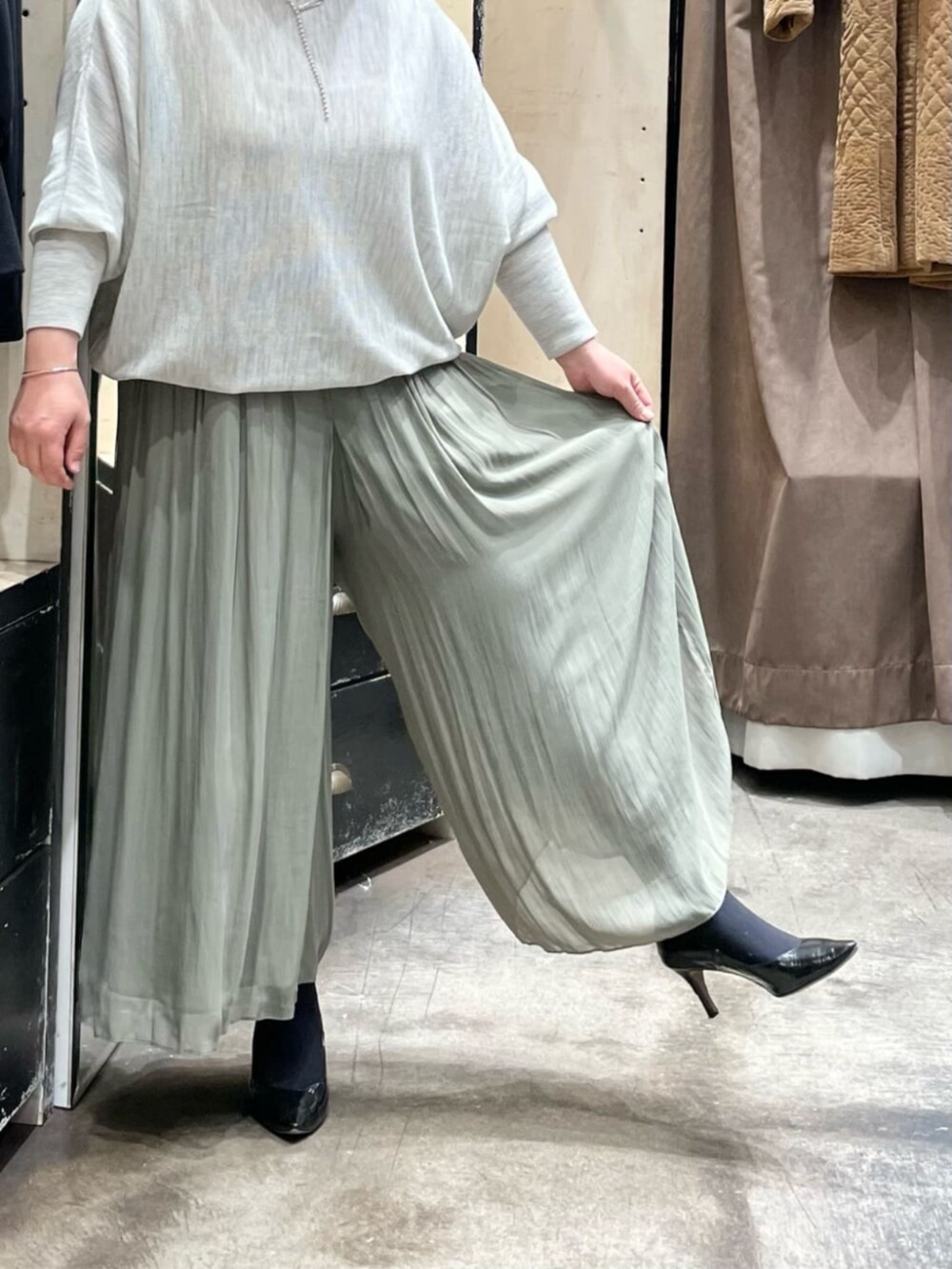 グレー系のニット/セーター、グリーン系のその他パンツ、ブラック系のトートバッグを着用したレディースの冬コーディネートの5枚目の写真