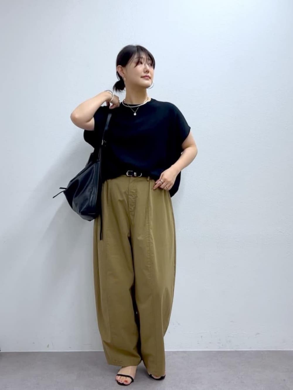 イエロー系のその他パンツ、ブラック系のニット/セーターを着用したレディースの夏コーディネートの2枚目の写真