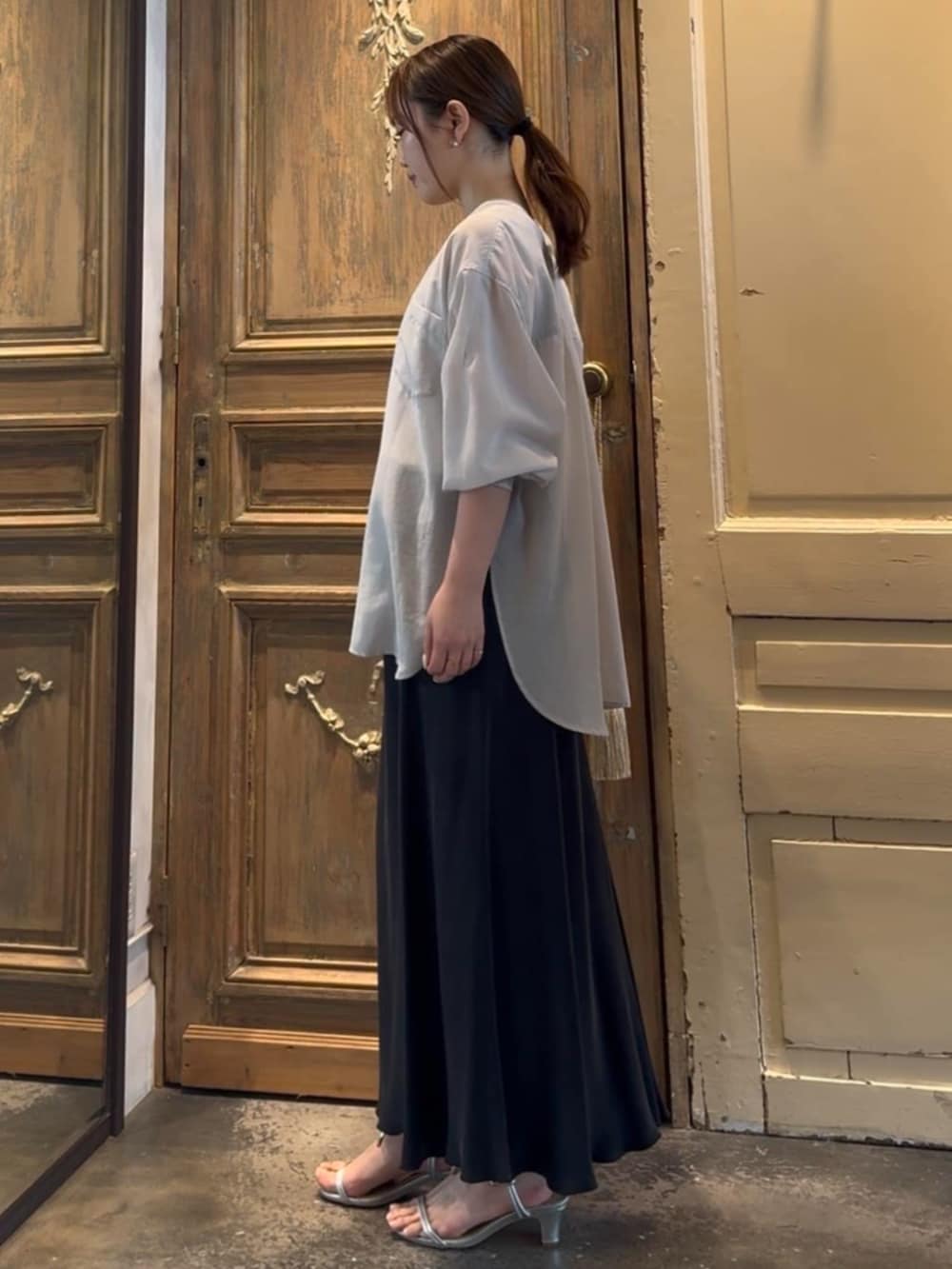 ブラック系のスカート、グレー系のシャツ/ブラウスを着用したレディースの冬コーディネートの2枚目の写真