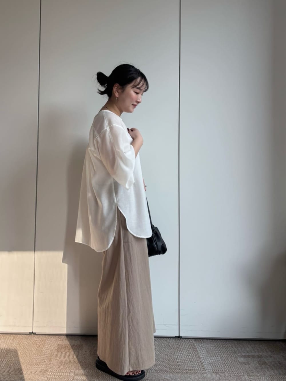 ベージュ系のその他パンツ、ブラック系のサンダル、ホワイト系のシャツ/ブラウスを着用したレディースの冬コーディネートの3枚目の写真