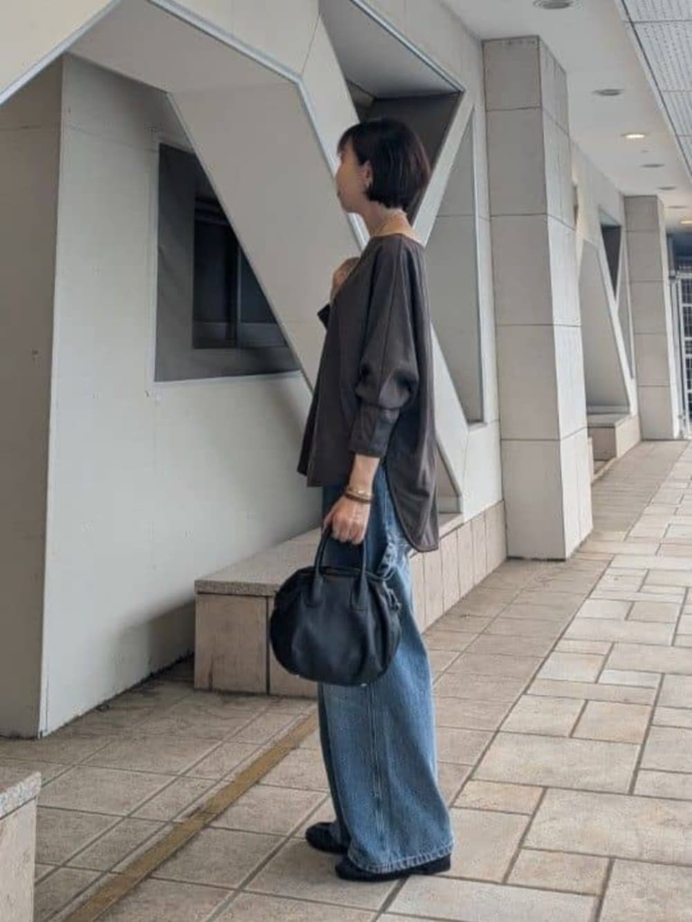 ブラック系のボストンバッグ、ブルー系のその他パンツ、ブラウン系のTシャツ/カットソーを着用したレディースの夏コーディネートの3枚目の写真