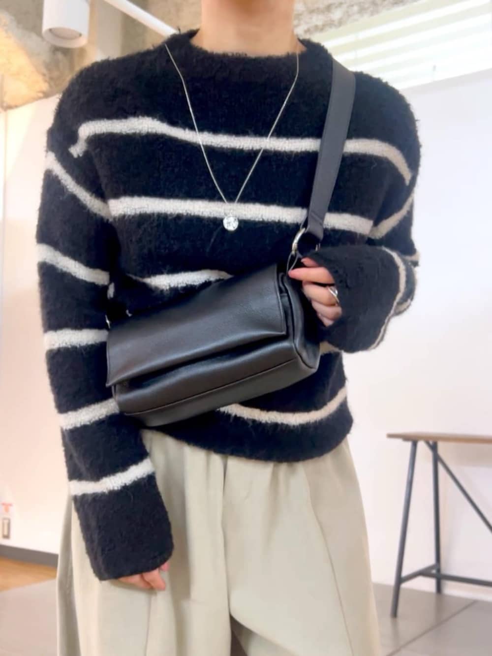 ブラック系のショルダーバッグ、グレー系のその他パンツ、ブラック系のニット/セーターを着用したレディースの秋コーディネートの5枚目の写真