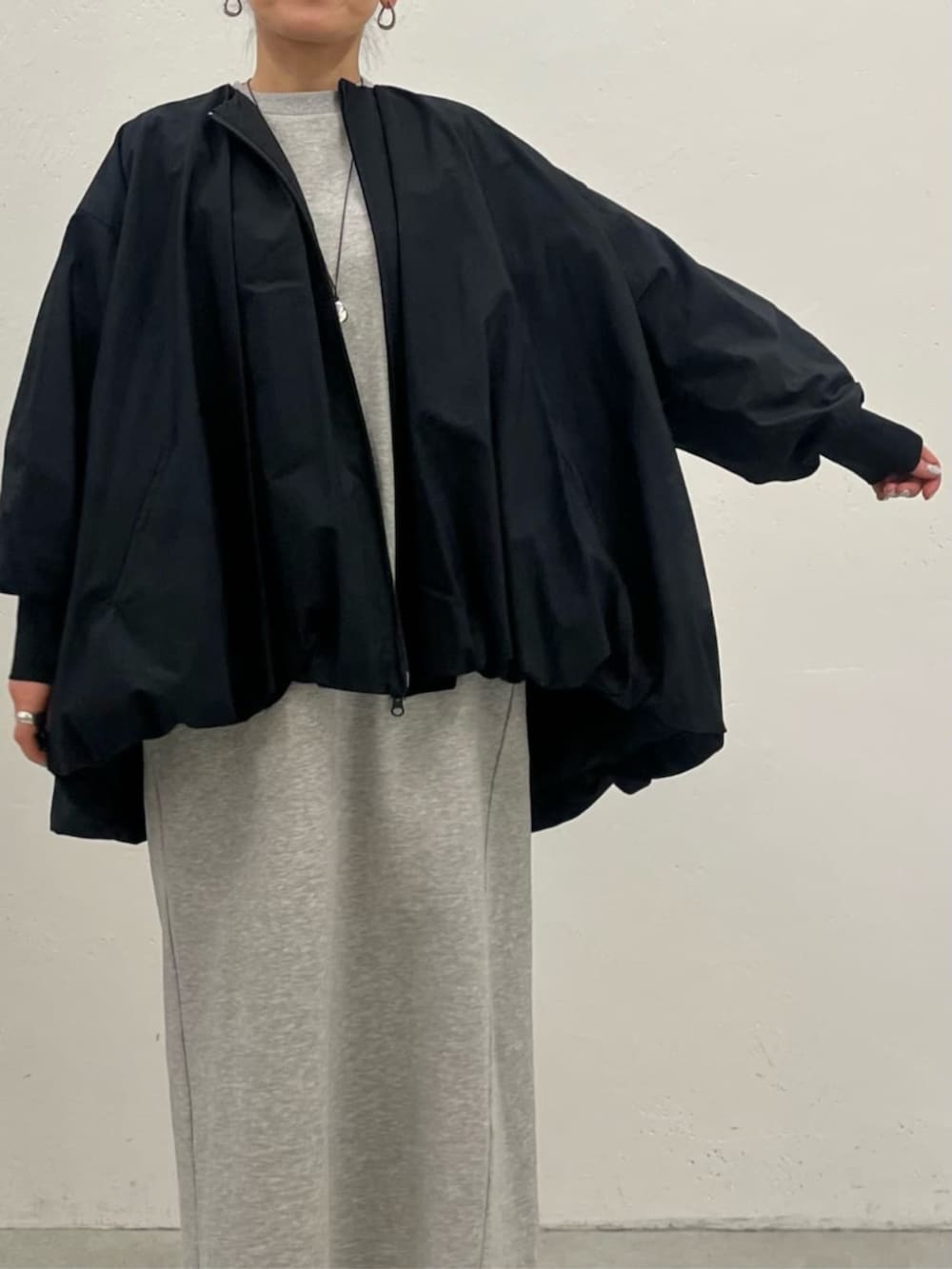 ブラック系のブルゾン、グレー系のワンピースを着用したレディースの冬コーディネートの9枚目の写真