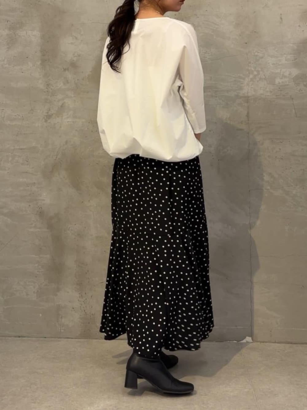 ホワイト系のシャツ/ブラウス、ブラック系のスカート、シルバー系のネックレスを着用したレディースの冬コーディネートの2枚目の写真