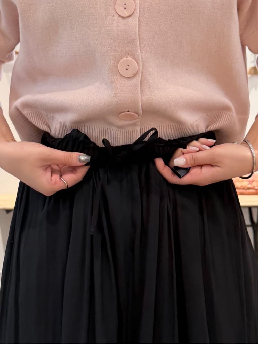 ブラック系のボストンバッグ、ブラック系のその他パンツ、ピンク系のカーディガン/ボレロを着用したレディースの冬コーディネートの6枚目の写真