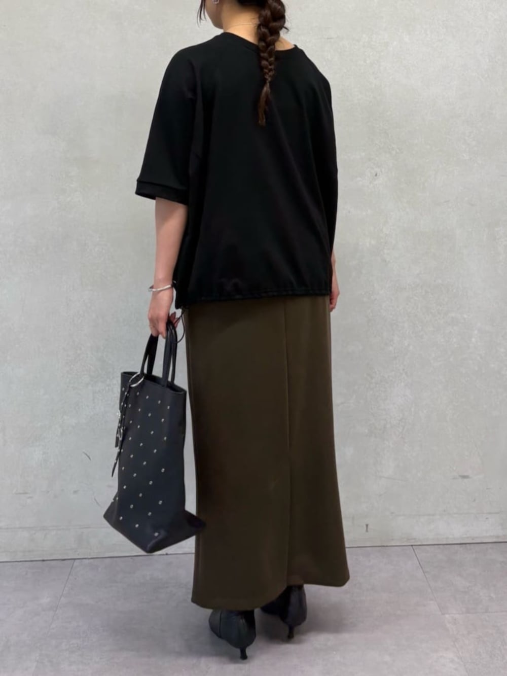 ブラック系のトートバッグ、ブラック系のTシャツ/カットソー、ブラウン系のスカートを着用したレディースの夏コーディネートの4枚目の写真