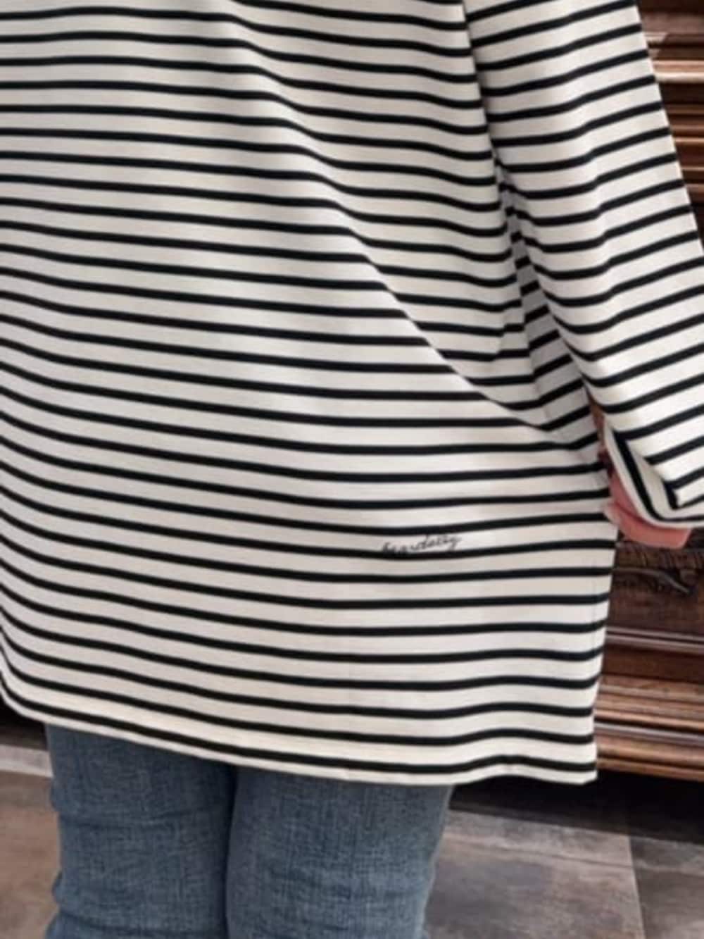 ブラック系のその他アウター、ブルー系のデニムパンツ、ブルー系のTシャツ/カットソーを着用したレディースの冬コーディネートの9枚目の写真