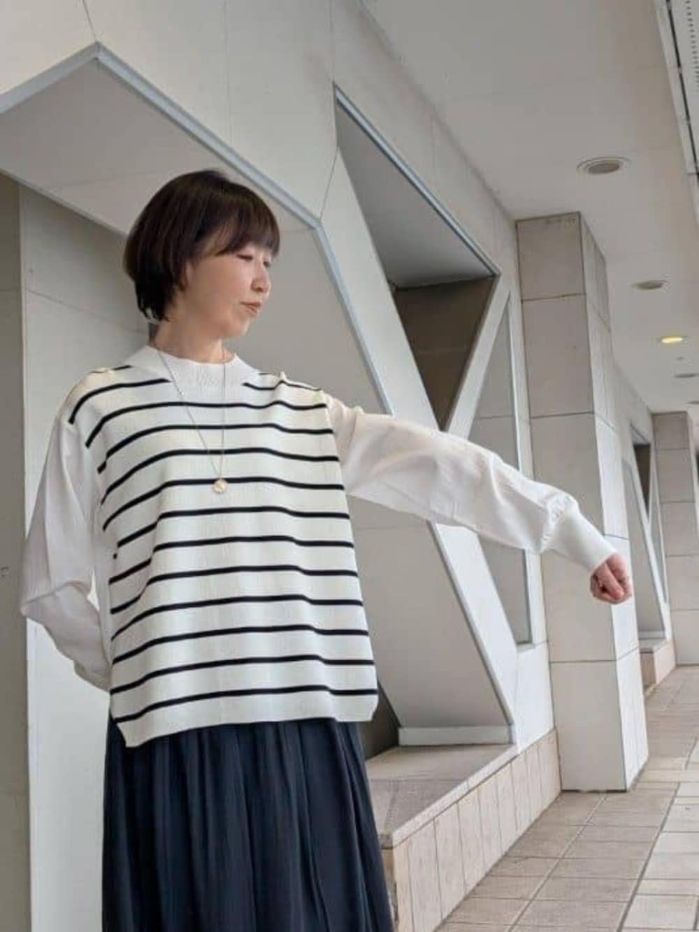 グリーン系のハンドバッグ、ブラック系のその他パンツ、ブラウン系のブルゾンを着用したレディースの冬コーディネートの7枚目の写真