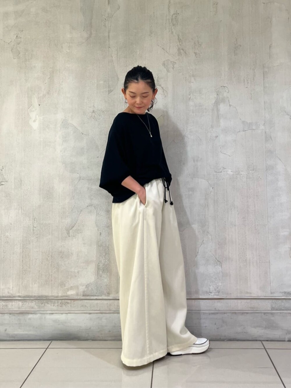 ブラック系のニット/セーター、ホワイト系のその他パンツを着用したレディースの冬コーディネートの4枚目の写真