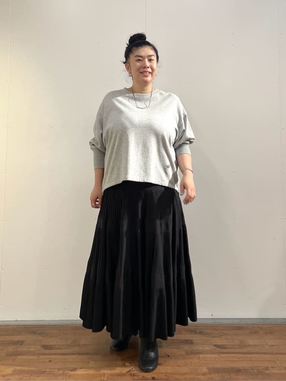 ブラック系のスカート、グレー系のTシャツ/カットソーを着用したレディースの夏コーディネートの3枚目の写真